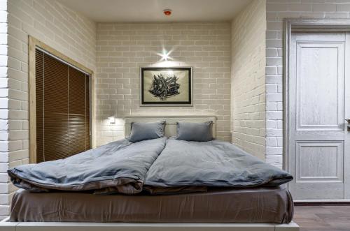 um quarto com uma cama grande numa parede de tijolos em Hotel Family em Pskov