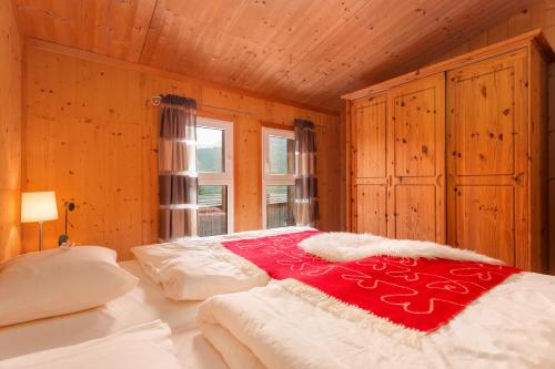 ホーエンタウアーンにあるChalet Sternwarteのベッドルーム1室(赤い毛布付きのベッド1台付)