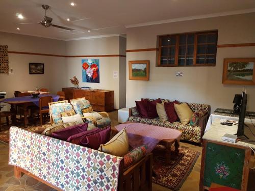 a living room with couches and a dining room at Crane Cottage in Colesberg