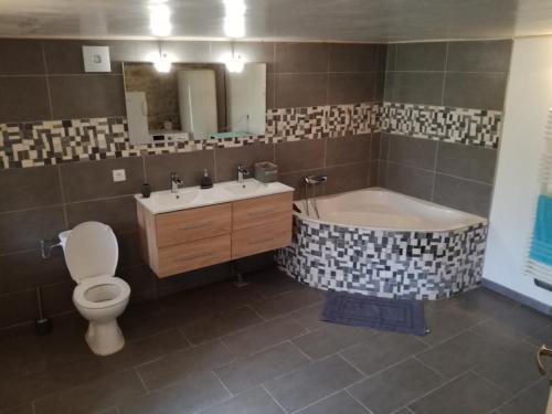 une salle de bain avec une baignoire, des toilettes et un lavabo dans l'établissement Gîte de caractère en pleine nature, à Bourg-de-Visa
