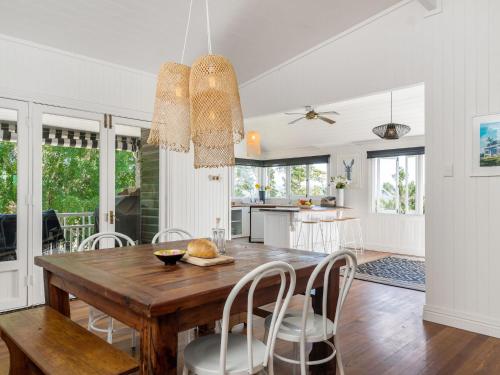 a kitchen and dining room with a wooden table and chairs at The Hideout House in Myocum