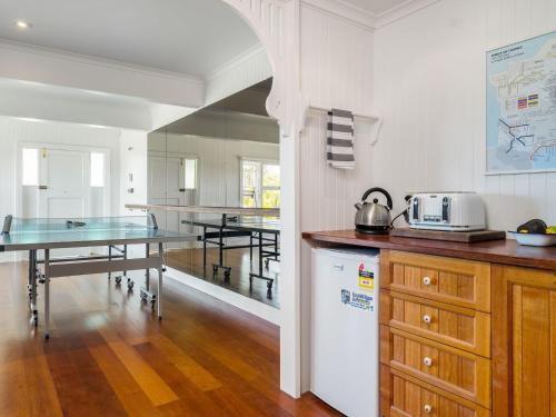 a kitchen with a table and a dining room at The Hideout House in Myocum