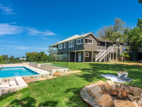 a house with a swimming pool and a yard at The Hideout House in Myocum