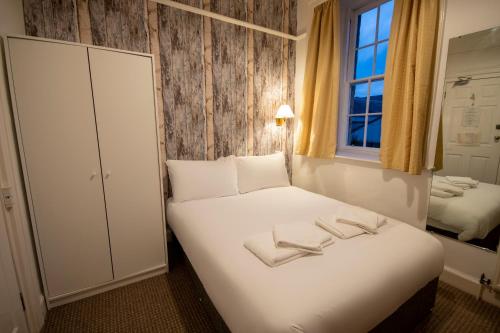 a bedroom with a bed with two towels on it at Douglas Arms Hotel in Castle Douglas