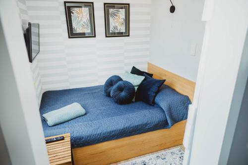 a bedroom with a blue bed with two pillows at Staromiejskie Premium in Zamość