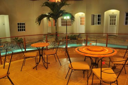 a balcony with tables and chairs and a swimming pool at Eco Hotel Katarma in Puerto Baquerizo Moreno