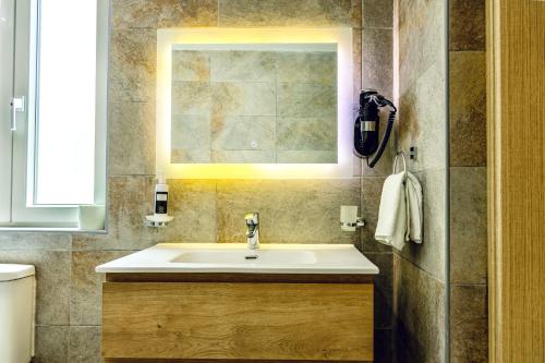 a bathroom with a sink and a window at The Mike Hotel by CX Collection in Cospicua
