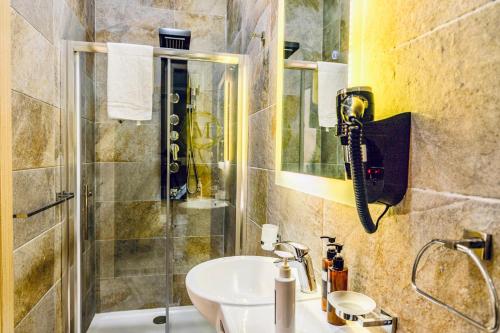 a bathroom with a sink and a shower at The Mike Hotel by CX Collection in Cospicua