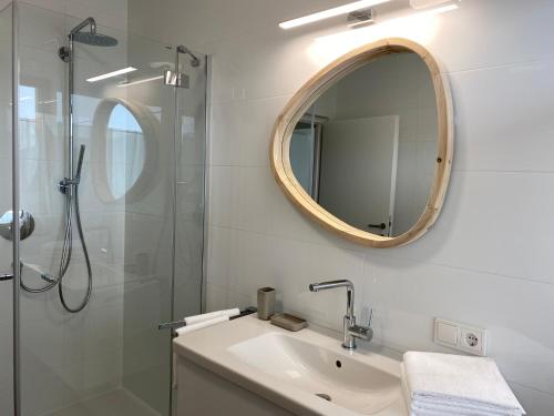 a bathroom with a sink and a shower with a mirror at Alpine Chalet Aurora Dolomites in Laion