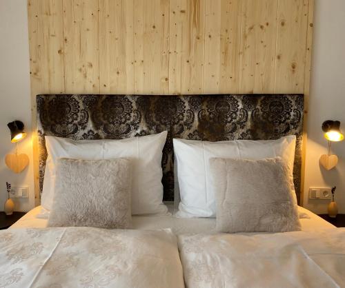 a bedroom with a large bed with white pillows at Alpine Chalet Aurora Dolomites in Laion