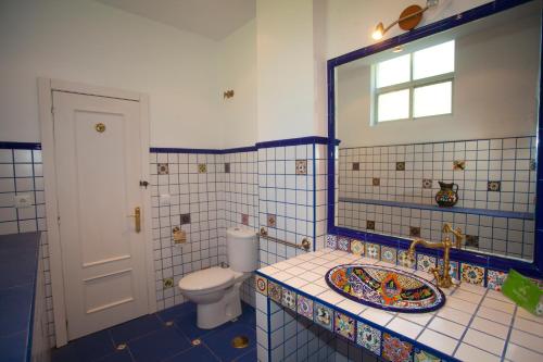 a bathroom with a toilet and a sink and a mirror at Villa Victoria in Vallobal