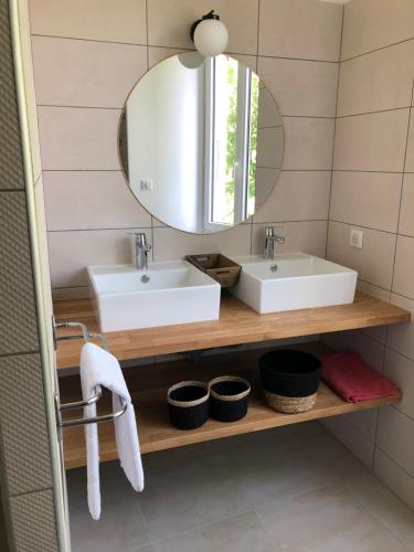 a bathroom with two sinks and a mirror at Manoir de Champvert in Les Vans