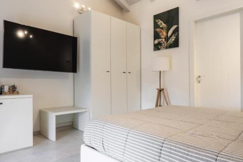 a bedroom with a bed and a flat screen tv at Ca' Ross in Formigine