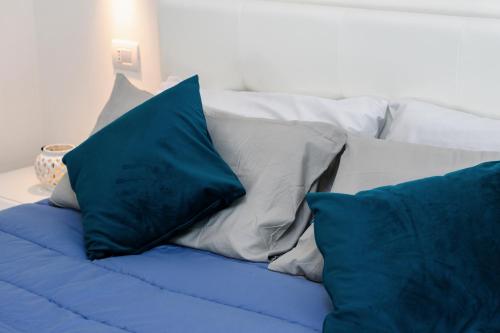 a bed with blue and white pillows on it at Ca' Ross in Formigine
