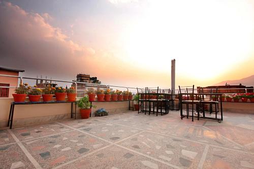 a balcony with chairs and potted plants on a building at Thamel Grand Hotel in Kathmandu