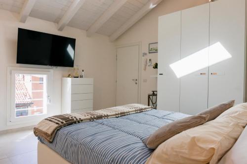 a bedroom with a bed and a flat screen tv at Ca' Ross in Formigine