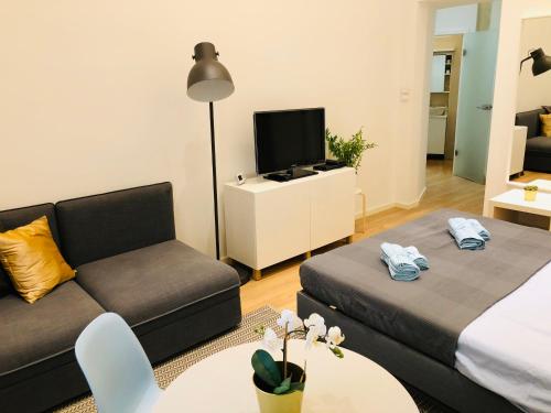 a living room with a couch and a tv at In My Style Apartman in Budapest