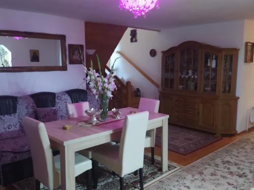 - une salle à manger avec une table, des chaises et un canapé dans l'établissement Casa Moldovita, à Moldoviţa