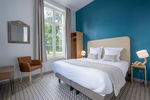a bedroom with a large bed with a blue wall at Chateau du Béron in Cappelle-en-Pévèle
