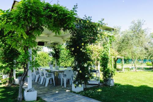 a table and chairs under a pergola in a garden at Ca' Ross in Formigine
