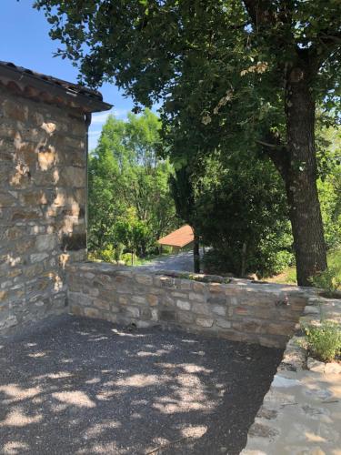 a stone wall with a tree behind it at Manoir de Champvert in Les Vans