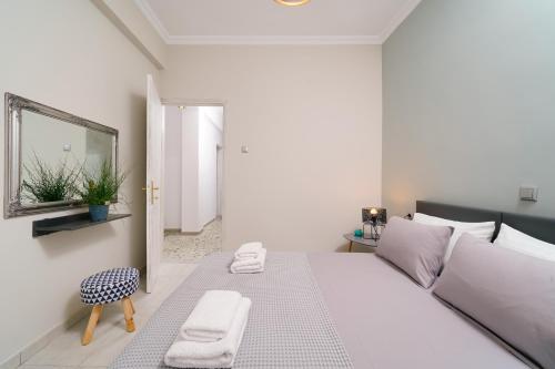 a white bedroom with a white bed and a mirror at Notos House in Limenaria