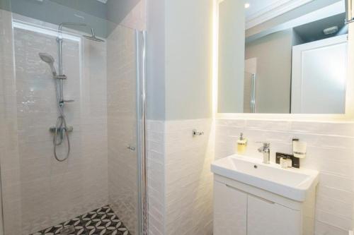 a white bathroom with a sink and a shower at THE YDRA VIEW APARTMENTS in Hydra