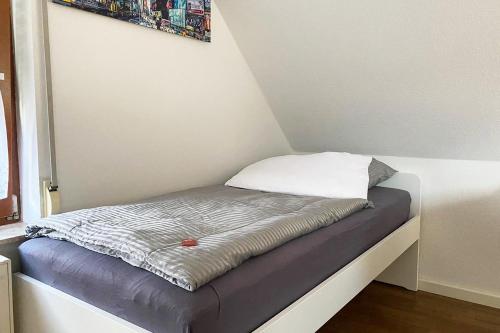 Una cama pequeña con una almohada encima. en Schönes 1 Zimmer Apartment mit Dachterrasse, en Glauchau