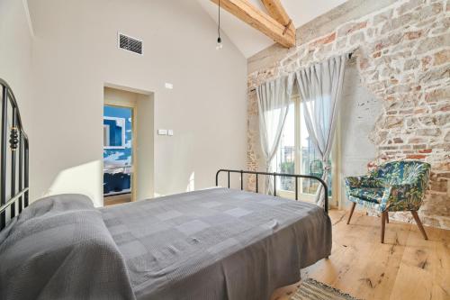 a bedroom with a bed and a brick wall at VILLA MEDITERANEA in Umag