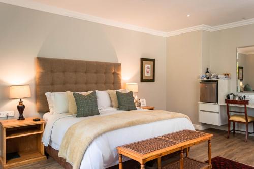 a bedroom with a large bed and a table at Van der Stel Manor in Stellenbosch