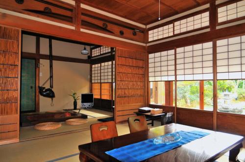 a dining room with a table and chairs and windows at Kotorian in Asuka