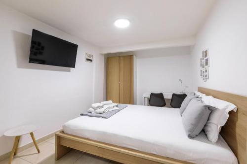 a bedroom with a bed with a tv on the wall at Αpartment in Rotonda (heart of Thessaloniki) in Thessaloniki