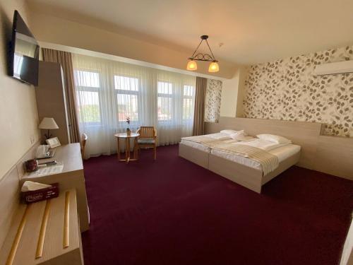 um quarto de hotel com uma cama e uma mesa em Pensiunea Rix Rooms em Focşani