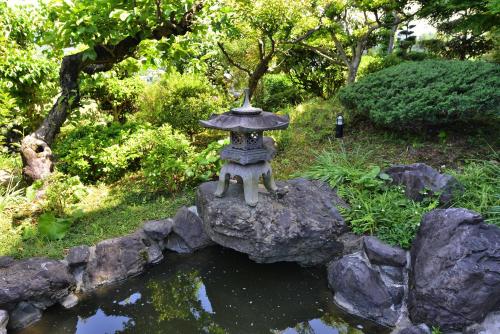 a stone statue on a rock near a pond at Kotorian in Asuka