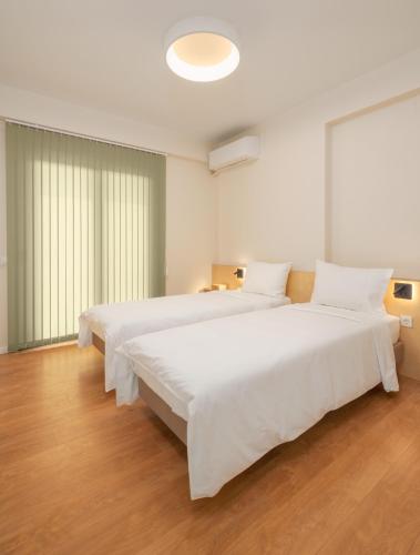 a large white bedroom with two large beds at ASTRA IN CITY in Ioannina
