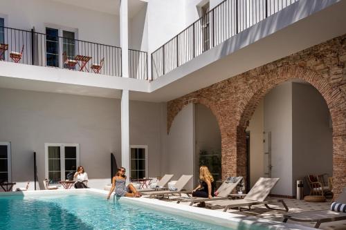 a group of people sitting in a swimming pool at Pousada Vila Real Santo Antonio in Vila Real de Santo António