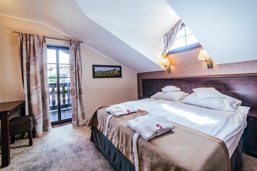 sypialnia z dużym łóżkiem z ręcznikami w obiekcie Hotel Kryształ Conference & Spa w Szklarskiej Porębie