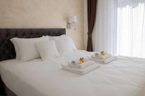 a white bed with towels on top of it at City Rooms in Sighetu Marmaţiei