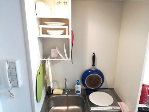 a kitchen with a sink in a small room at Morinomiya Flat 森ノ宮フラット in Osaka