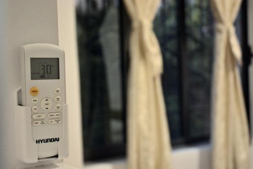 a remote control attached to a wall with a window at Hotel Reci in Peshkopi