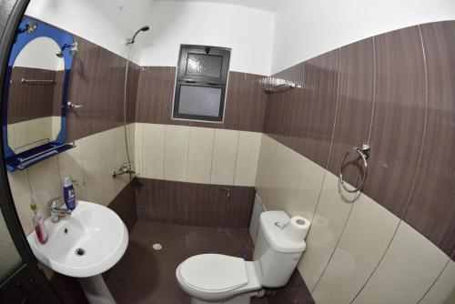 a bathroom with a white toilet and a sink at Hotel Reci in Peshkopi