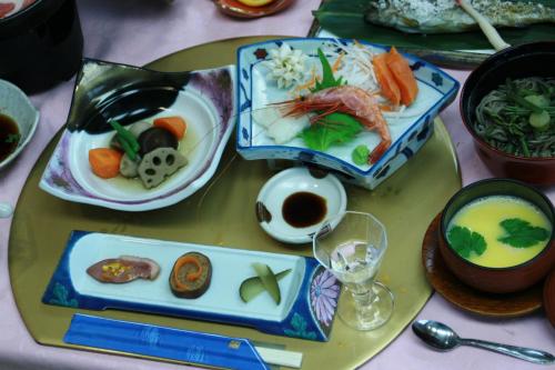 a table with several plates of food on it at Alpine Route Hotel in Omachi