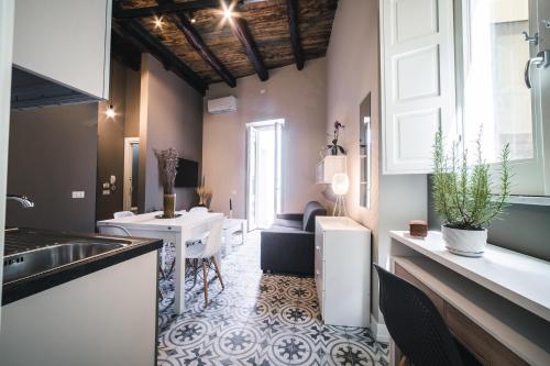 eine Küche mit einem Waschbecken und einem Tisch in einem Zimmer in der Unterkunft Palazzo Paladini - Luxury Suites in the Heart of the Old Town in Pizzo