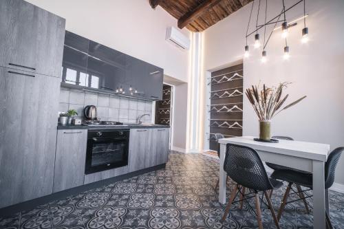 a kitchen with a table and chairs and a stove at Palazzo Paladini - Luxury Suites in the Heart of the Old Town in Pizzo