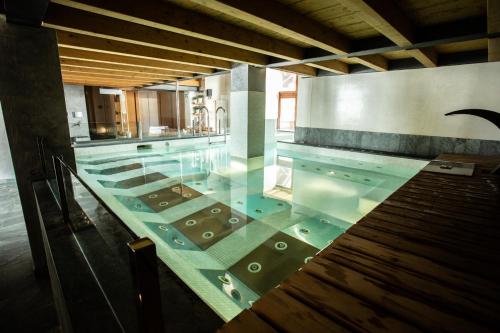 una gran piscina con suelo de cristal en Sertorelli Sporthotel, en Breuil-Cervinia