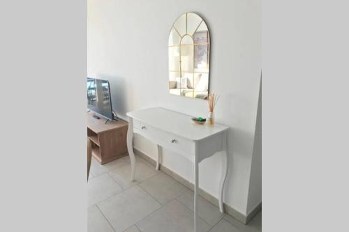 ein Bad mit einem weißen Waschtisch und einem Spiegel in der Unterkunft Le Bleu Mer in Sète