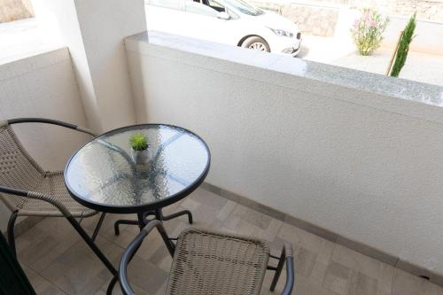 a small plant sitting on a glass table next to a chair at Sea Point Villa Ivan in Kornić