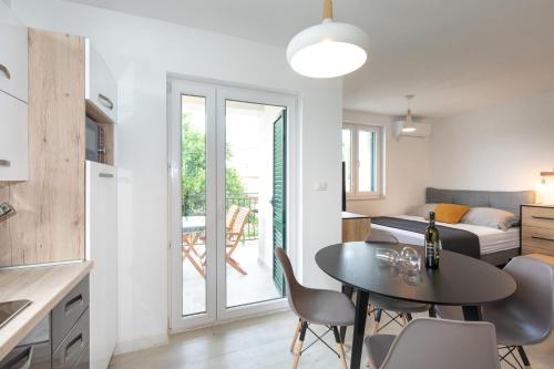 a kitchen and living room with a table and chairs at Sea Point Villa Ivan in Kornić