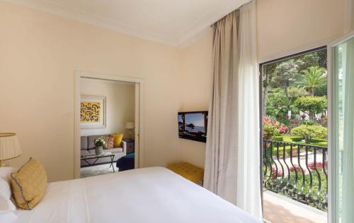 a bedroom with a bed and a large window at Villa Sant'Andrea, A Belmond Hotel, Taormina Mare in Taormina