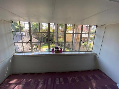 an empty room with a large window in a house at Ndzuti Guest House in Witbank